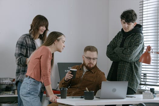 A group of young professionals engaged in a collaborative meeting in a modern office setting.