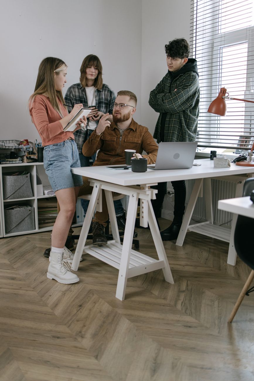 A group of young professionals engaged in a creative meeting in a modern office setting.
