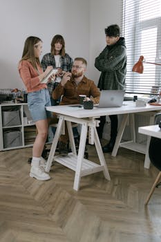 A group of young professionals engaged in a creative meeting in a modern office setting.