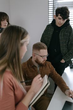 A diverse group of professionals collaborating on a project in an office.