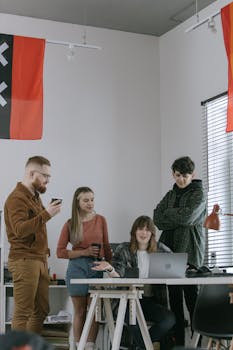 A group of young professionals engaged in a collaborative meeting in a modern office setting.