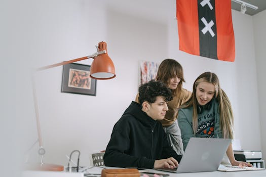 A diverse group of young adults collaborating on a project in a modern office setting.