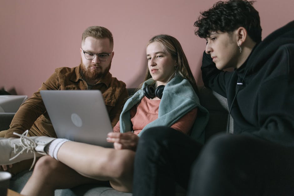 Young diverse team collaborates on a project using a laptop in an office setting.