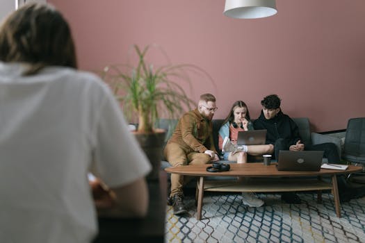 A diverse group of young professionals collaborating on a project in a contemporary office setting.