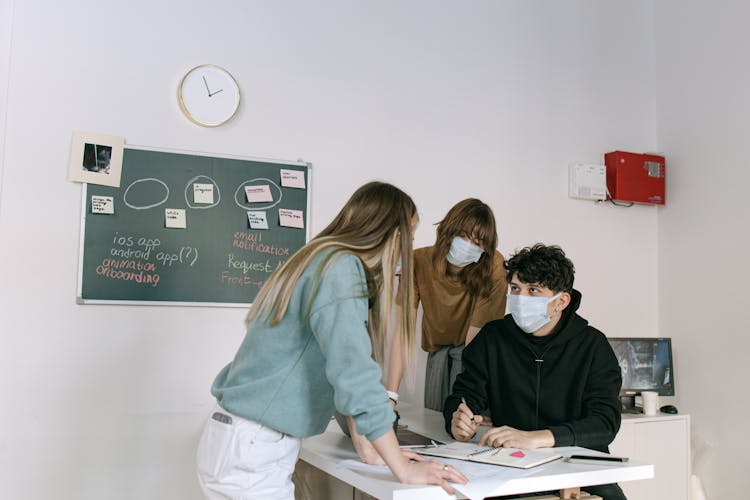 A Group Of People Talking While Wearing Face Mask