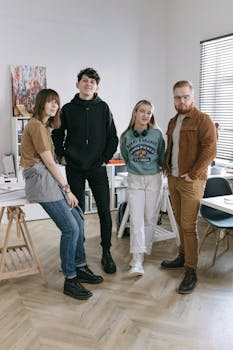 A group of diverse young adults posing together in a modern office environment.