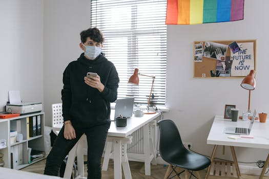 Young man in a modern office wearing a mask, symbolizing the new normal and workplace safety.