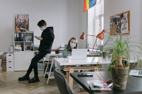 Free Two masked individuals working in a contemporary office setting, embracing the new normal. Stock Photo