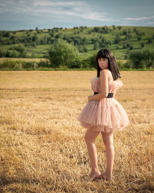 Woman in Pink Tulle Dress Standing in a Farmland