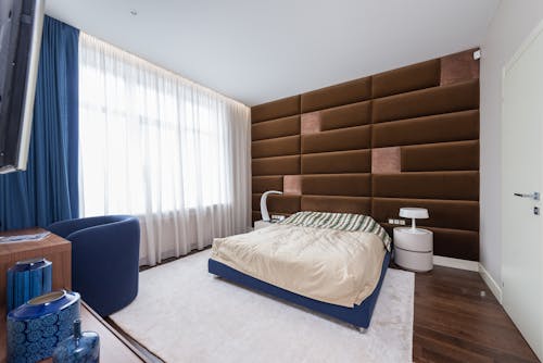 Interior of contemporary bedroom with comfortable soft bed and stylish furniture in flat in daytime