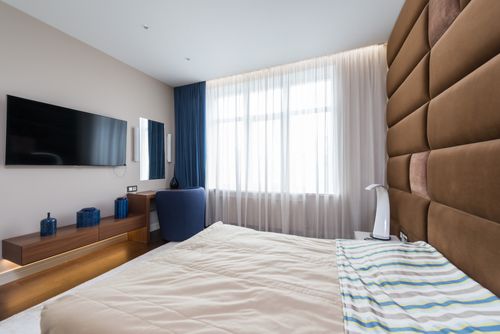 Free Comfortable bed placed opposite TV with black screen in modern bedroom in apartment Stock Photo