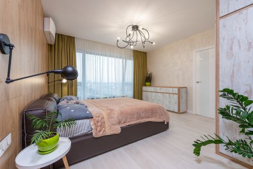 Free Interior of contemporary bedroom with large comfortable bed and green potted plants in flat in daytime Stock Photo