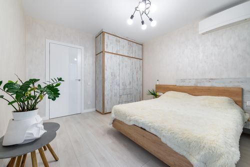 Free Bright and airy minimalist bedroom with wood accents and stylish decor. Stock Photo
