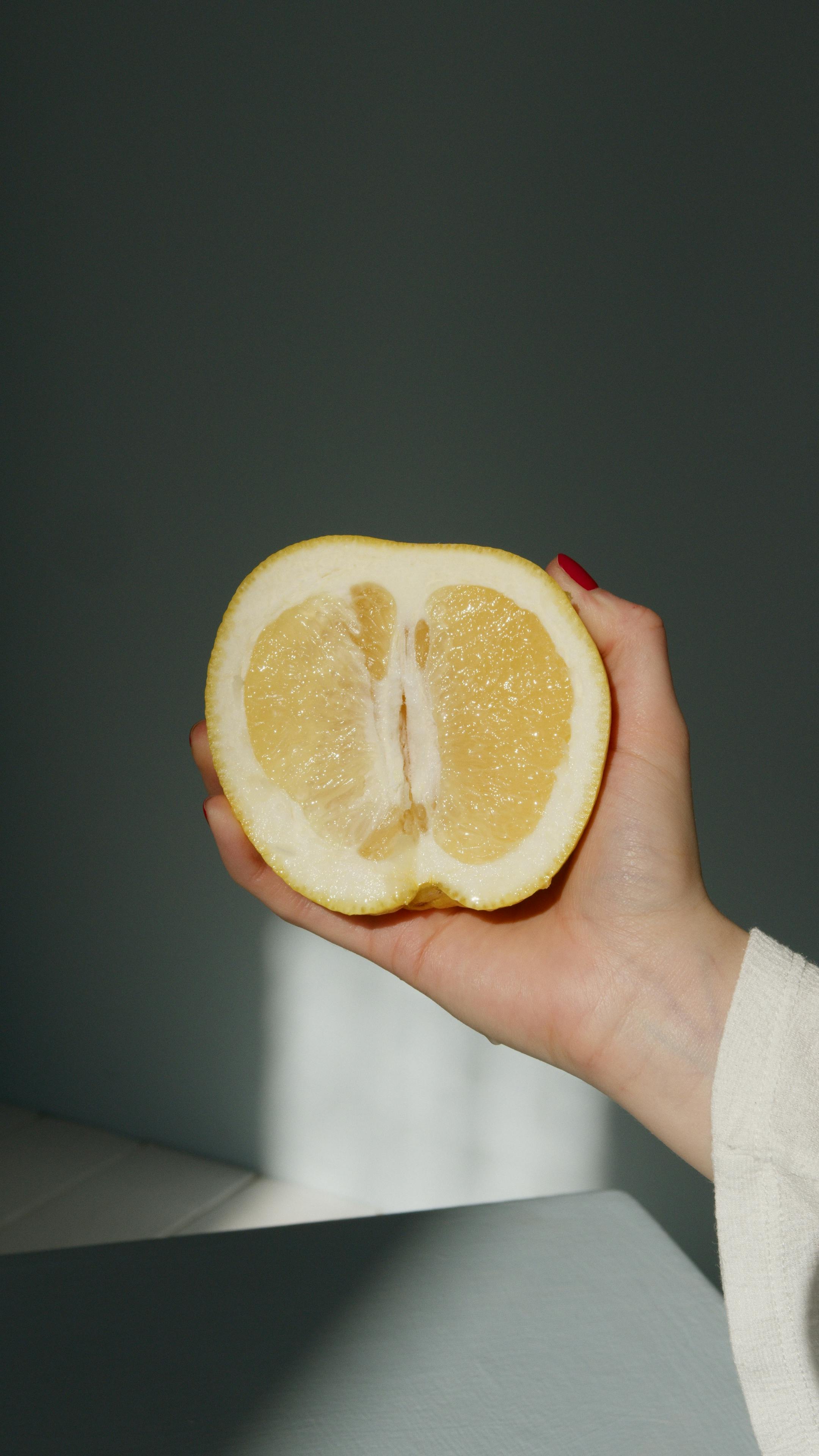 person holding sliced lemon fruit