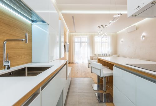 Bright galley kitchen with an island and pale cabinetry — photo by Max Vakhtbovych on Pexels
