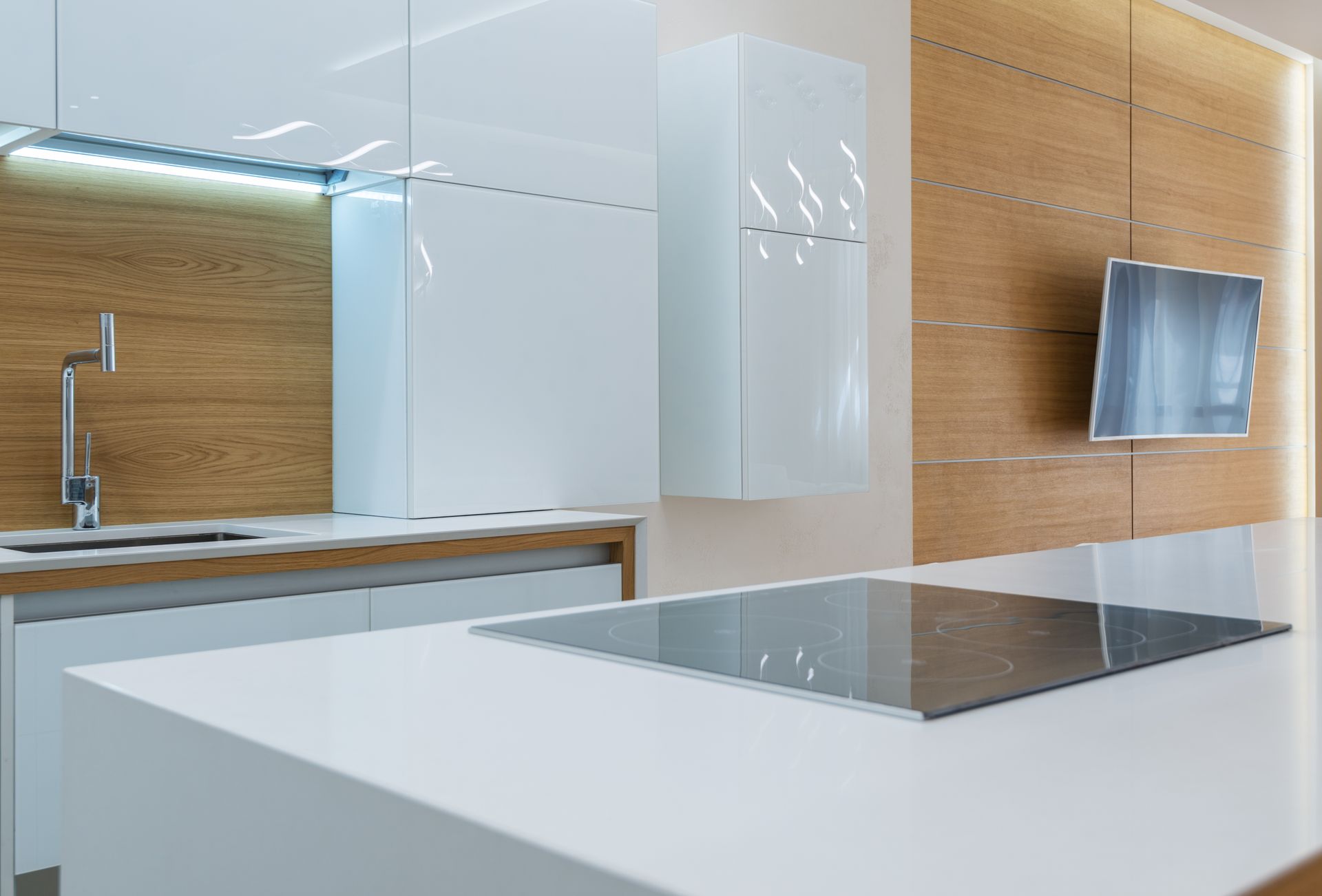 Clean kitchen counter with stove against white cabinets and wooden walls in spacious contemporary apartment