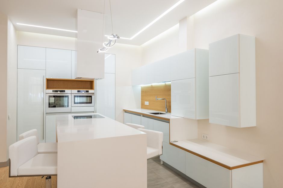 Interior of new contemporary kitchen with clean white furniture in luxury apartment in daytime - High Quality Performance Evaluation