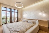 Trendy light bedroom with balcony