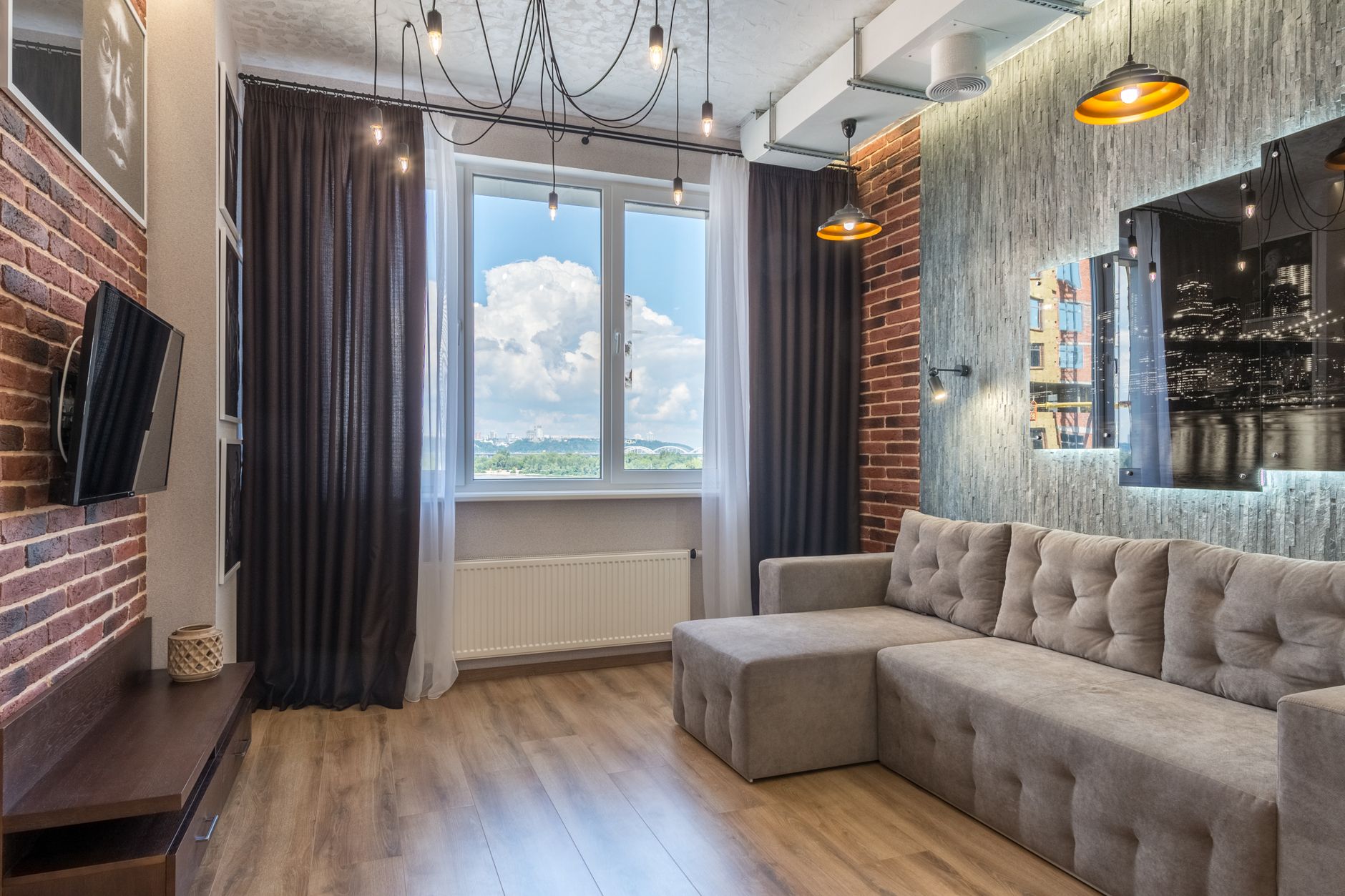 Contemporary living room featuring urban decor, large window view, and stylish furnishings.