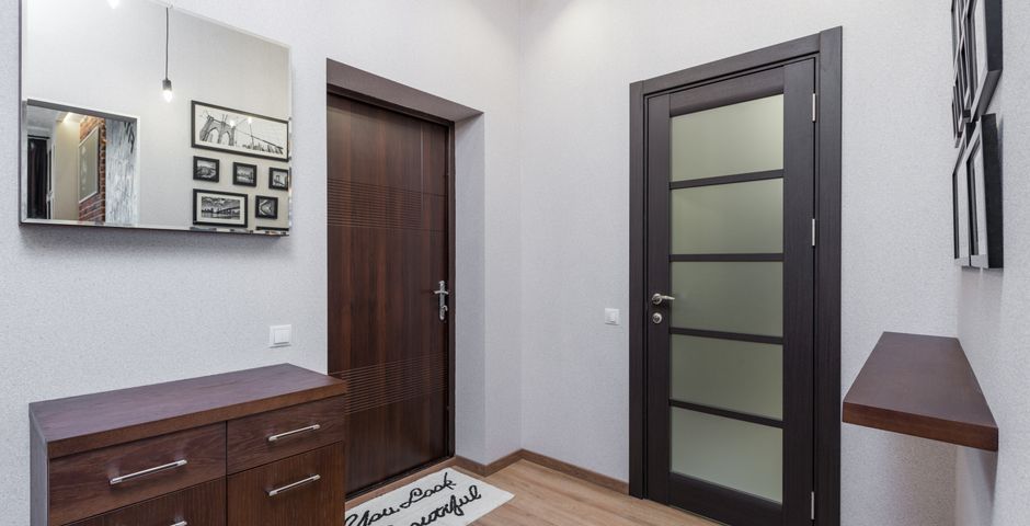 A hallway with dark timber elements — door frames and skirtings are sounded rather than just looked at