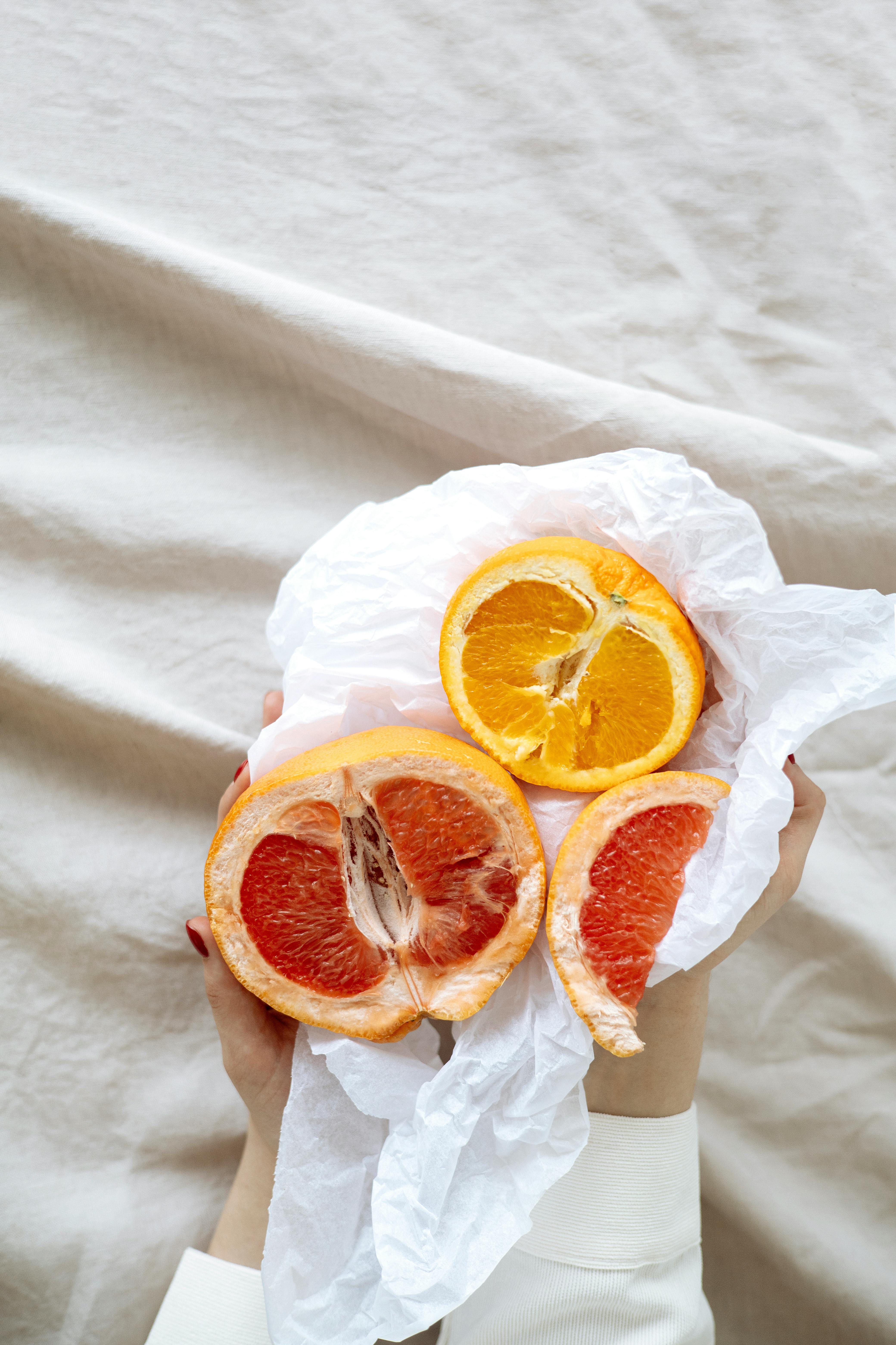 sliced orange fruit on white textile