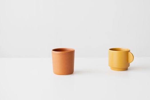Two ceramic cups on a plain white background showcasing minimalist design.