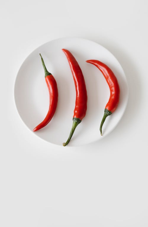 Free Three Cayenne Peppers on a White Saucer Stock Photo