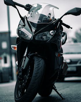 Close-up of a sleek black Kawasaki motorcycle parked on an urban street, exuding power.