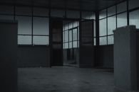 Interior of spacious empty room of gloomy abandoned building with glass windows and opened door