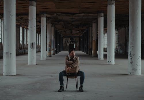 Man sitting in abandoned building with columns