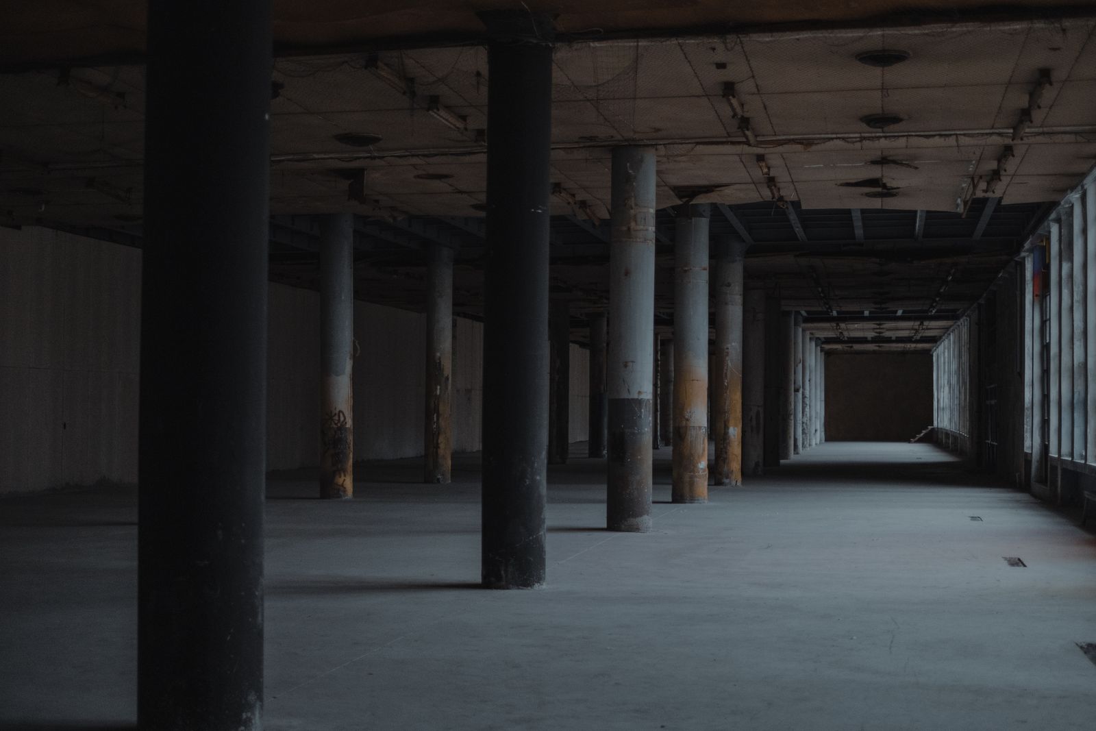 Empty concrete hall lined with columns, photo by Faruk Tokluoğlu on Pexels