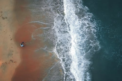 Top View of Man Watching at Waves Crushing on Sandy Beach