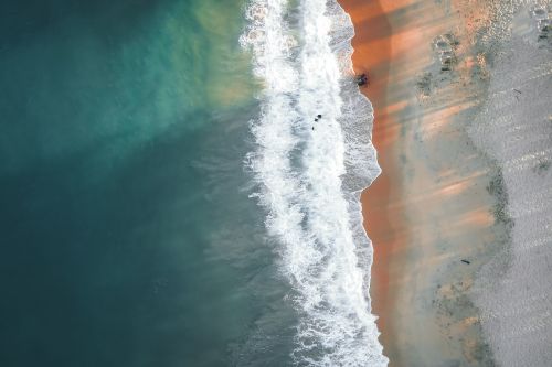 Free Top-down view of waves meeting sandy beach in Terengganu, Malaysia, showcasing natural beauty and ocean patterns. Stock Photo