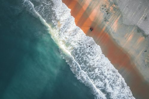 Free Stunning aerial view of waves meeting the sandy beach in Terengganu, Malaysia. Stock Photo