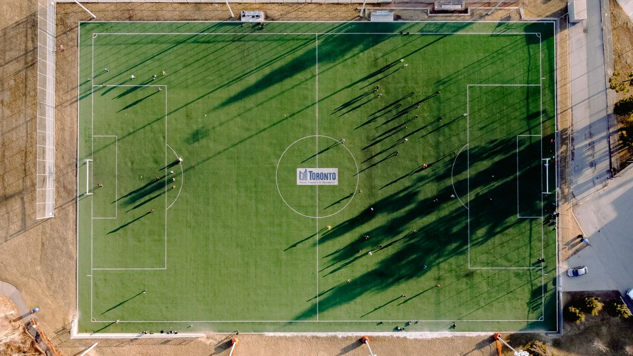 aerial view of soccer field with anonymous sportspeople and shades aga