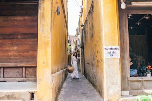 Free Woman in a Dress Posing in an Alley Stock Photo