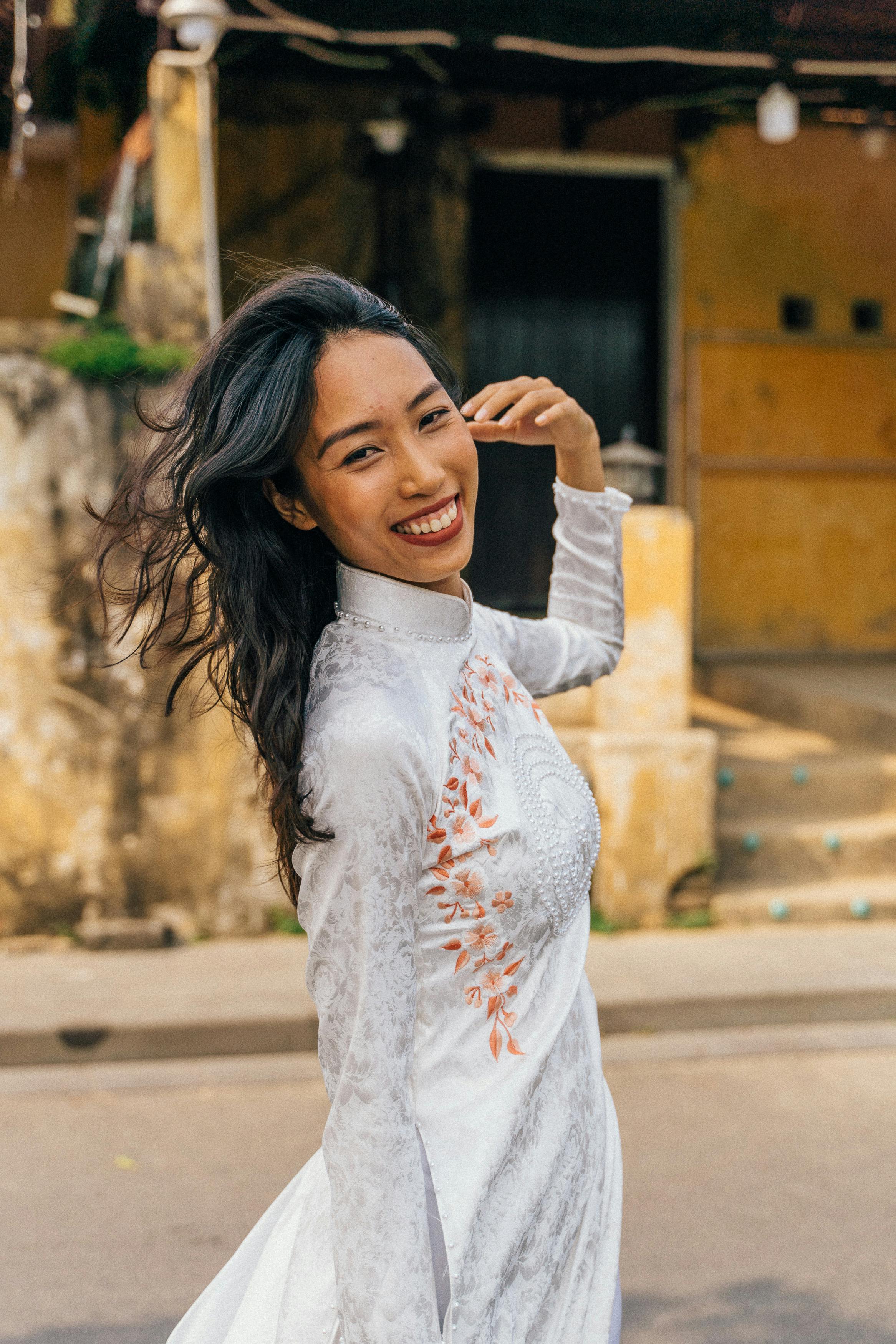 a smiling woman wearing ao dai