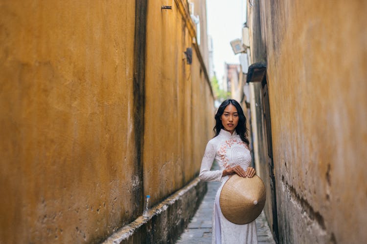 Woman Holding A Rice Hat Standing On A Walkway