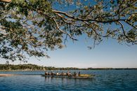 Anonymous sportspeople in canoes on river in summer
