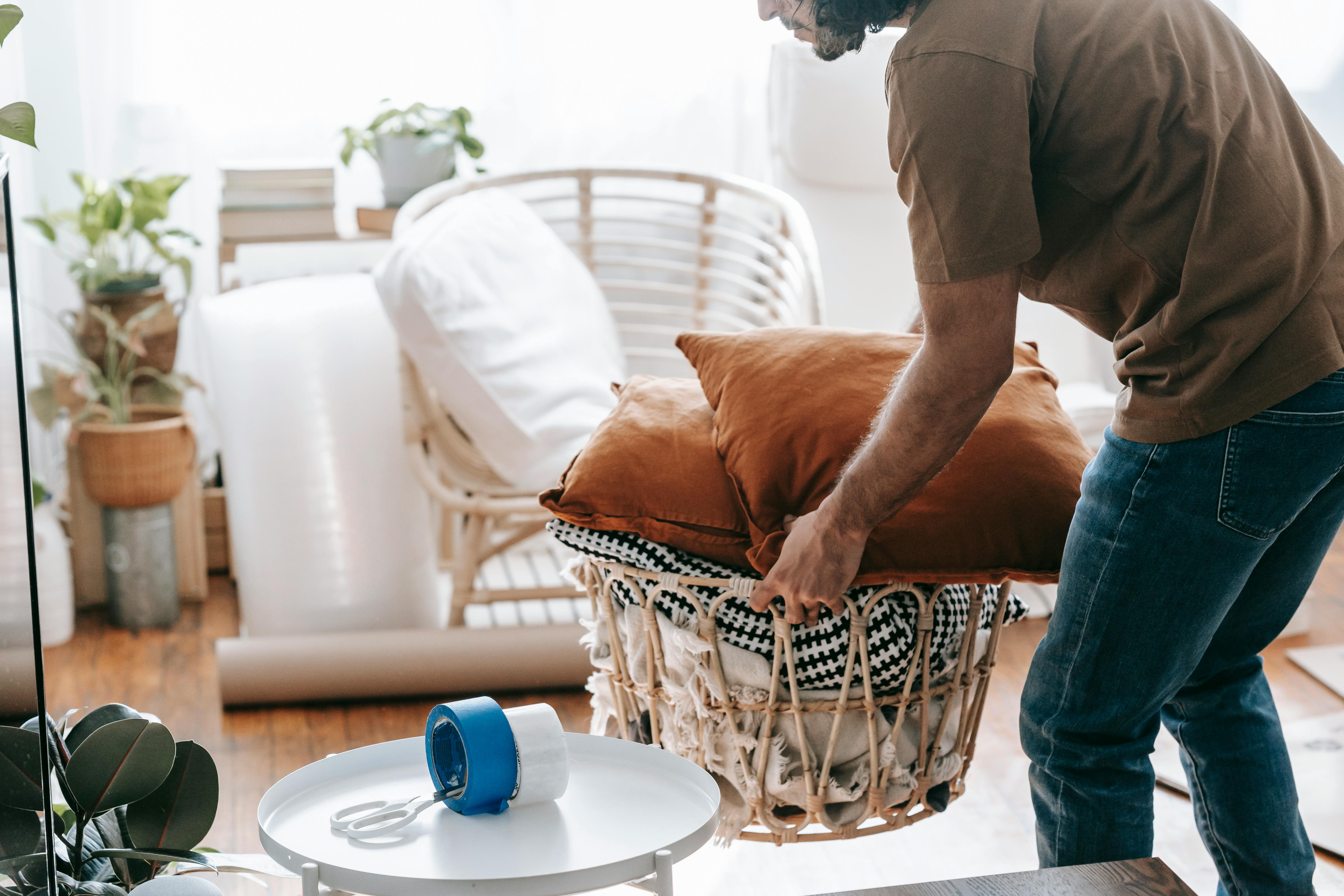 man carrying a basket with cushions