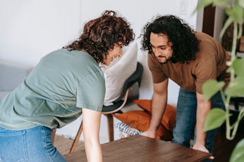 Free A Couple Lifting A Wooden Table Stock Photo