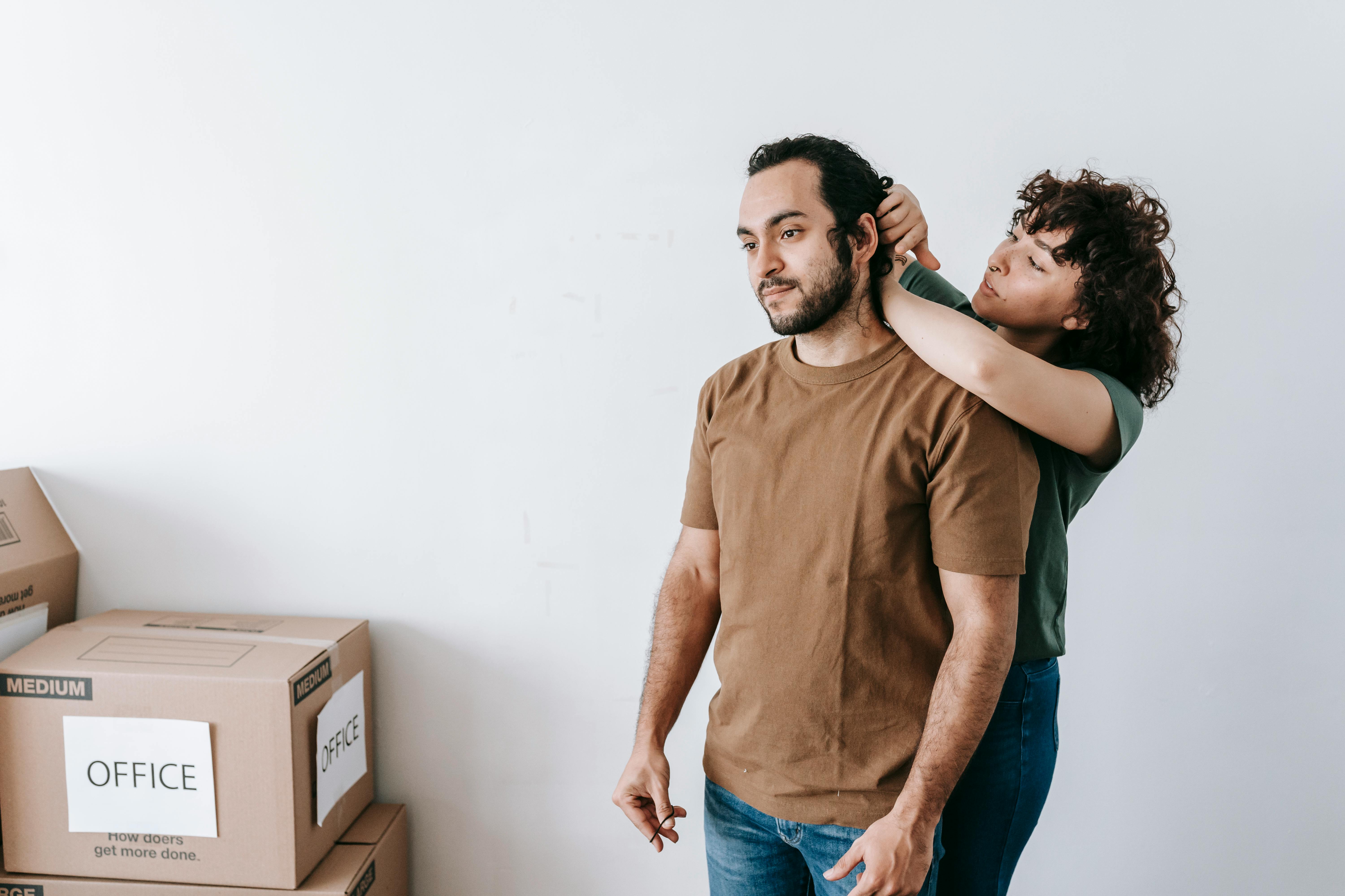 Couple preparing to move by packing boxes in their modern apartment, symbolizing new beginnings.