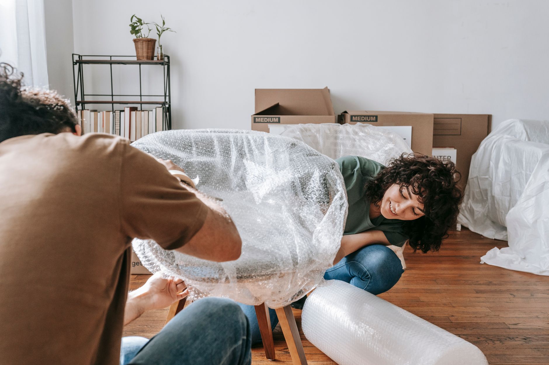 assortment of bubble wrap air pillows cardboard boxes and packing paper on a packing station