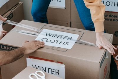 Hands packing a labeled moving box