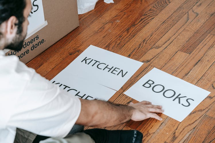 Man Looking At Printed Materials On Floor