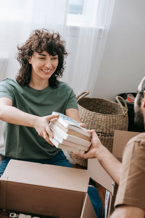 A Couple Packing Up Books To A Box · Free Stock Photo