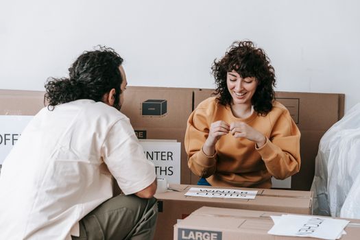 A happy couple organizing boxes while packing for a new home indoors.