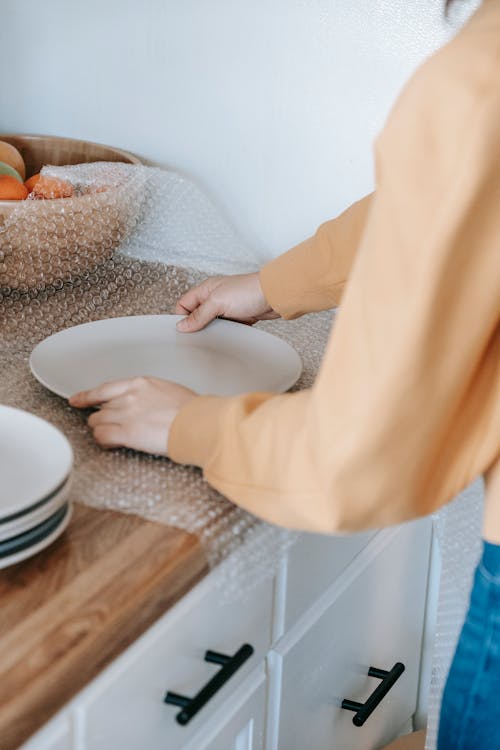 Free Person Packing A Plate With Bubble Wrap Stock Photo