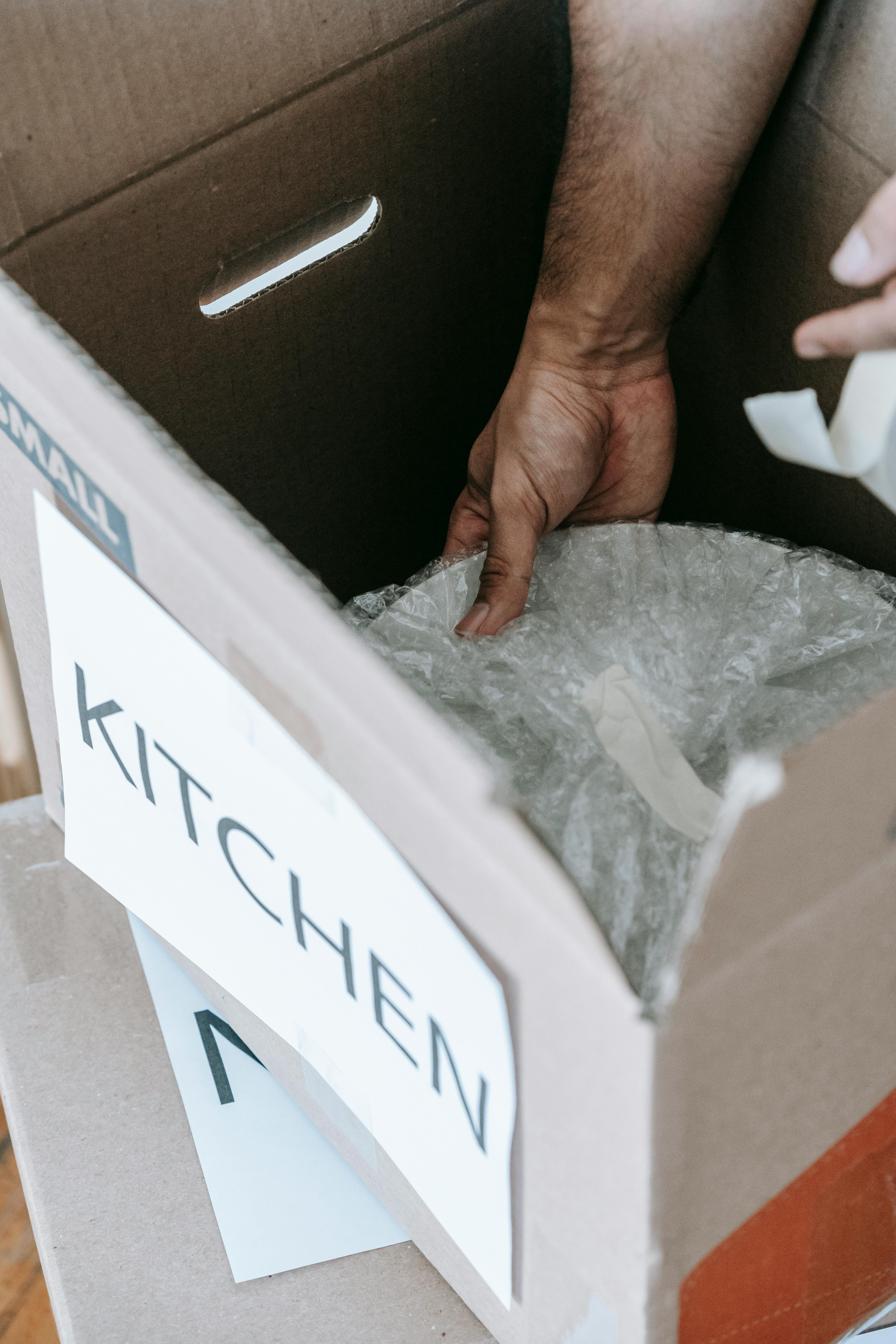 person packing up kitchen wares