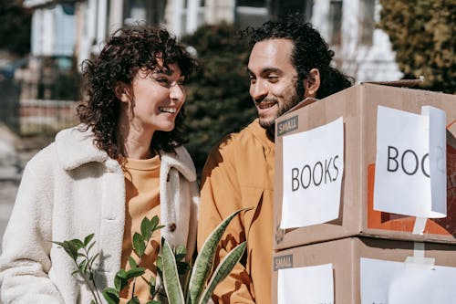 Free Couple Moving Out Carrying Boxes And Plants Stock Photo